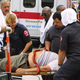 Paramedics administer first aid to a man who collapsed from smoked-sausage inhalation.